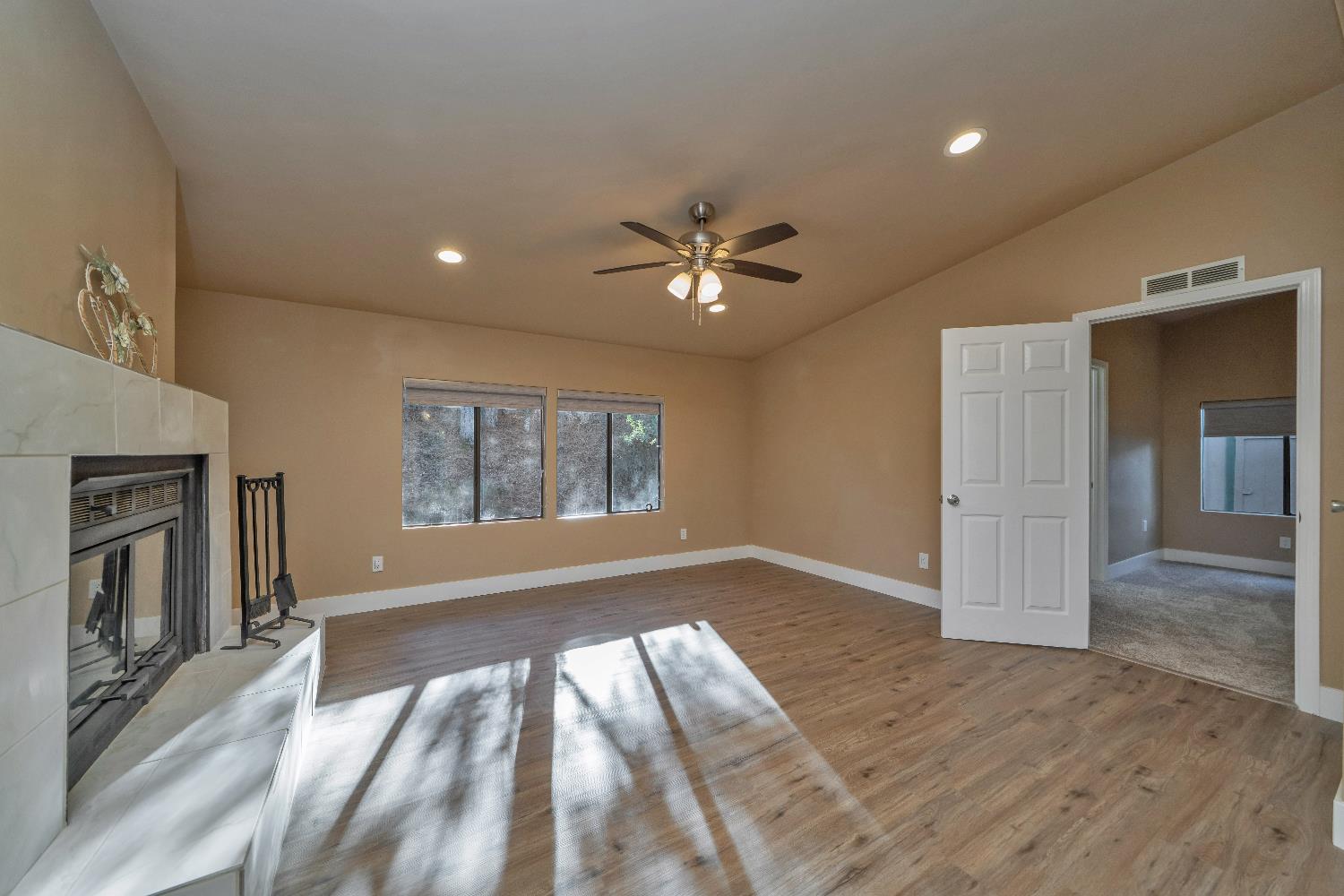 4420 Pleasant Valley Road, Unit 155 Diamond Springs, CA 95619 - Photo 11 of 42 an empty room with wooden floor and a ceiling fan
