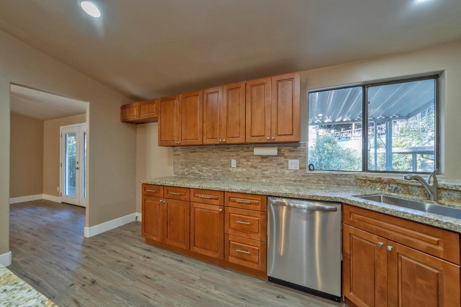 4420 Pleasant Valley Road, Unit 155 Diamond Springs, CA 95619 - Photo 17 of 42 a kitchen with granite countertop wooden cabinets a sink and dishwasher with wooden floor