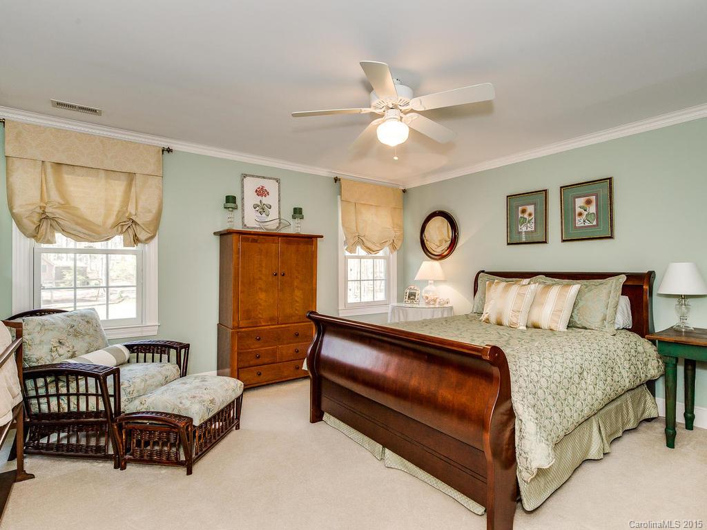 3402 Gray Moss Road Charlotte, NC 28270 - Photo 14 of 24 a bedroom with a bed and a chandelier