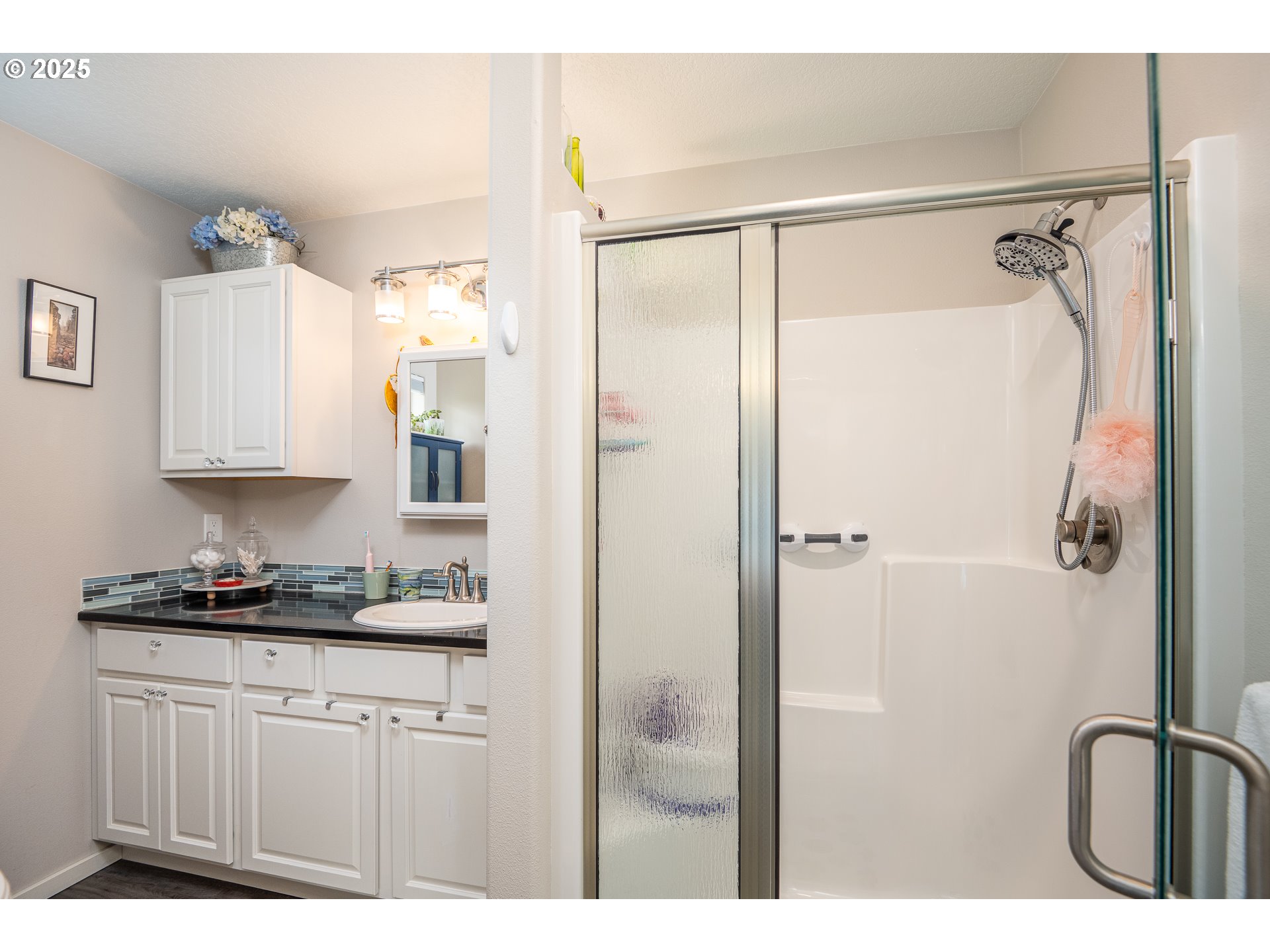 1602 Northwest Oceanic Loop Waldport, OR 97394 - Photo 22 of 47 a bathroom with a granite countertop sink a mirror a vanity and a shower
