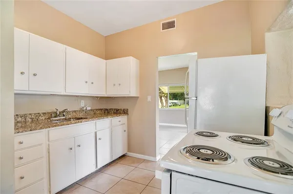 a kitchen with a stove and white cabinets