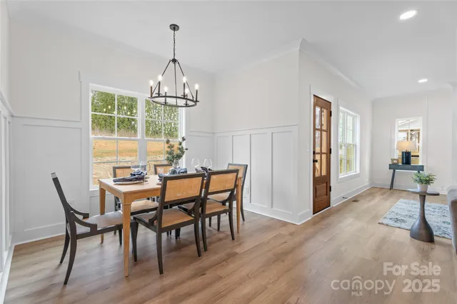 a kitchen with a dining table chairs stove and cabinets
