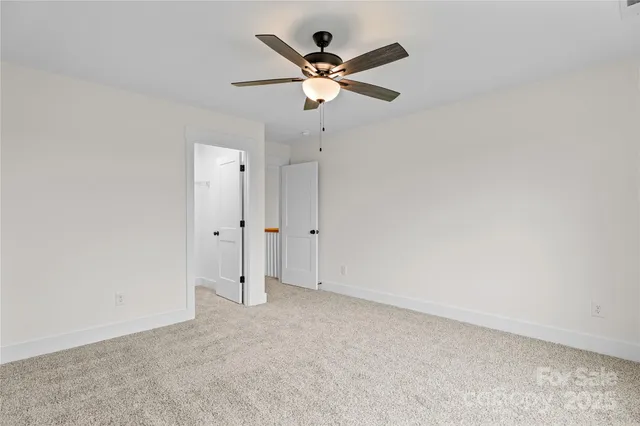 an empty room with fan and windows