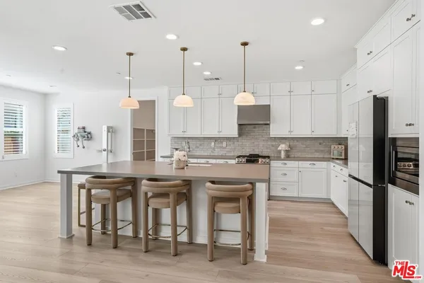 a kitchen with stainless steel appliances granite countertop a sink a stove and a refrigerator