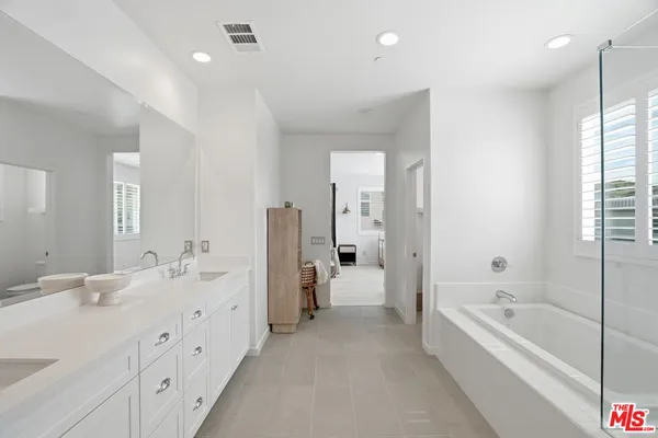 a spacious bedroom with a furniture and a window