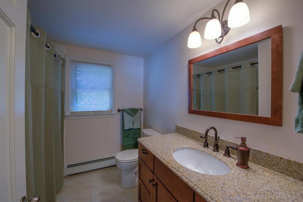 90 Ralyn Road Cotuit, MA 02635 - Photo 17 of 29 a bathroom with a granite countertop sink a toilet and a mirror