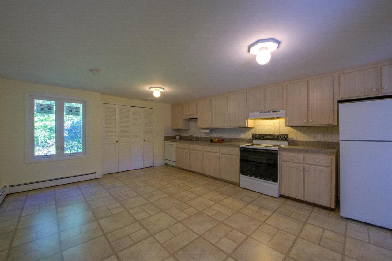 90 Ralyn Road Cotuit, MA 02635 - Photo 10 of 29 a kitchen with a sink a stove top oven and kitchen island