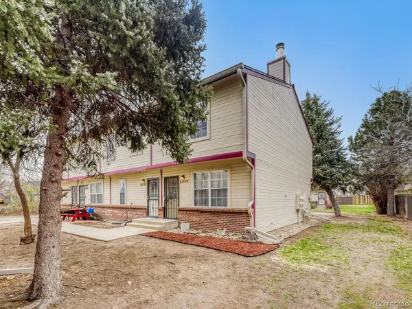 a view of a house with a yard and tree