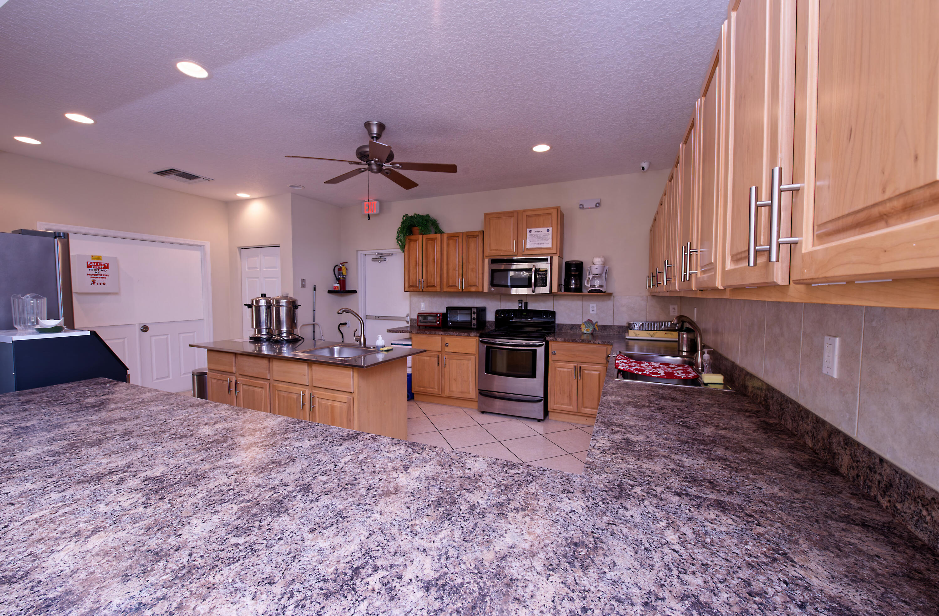 632 Snug Harbor Drive, Unit D15 Boynton Beach, FL 33435 - Photo 21 of 50 a large kitchen with kitchen island granite countertop a stove sink and cabinets