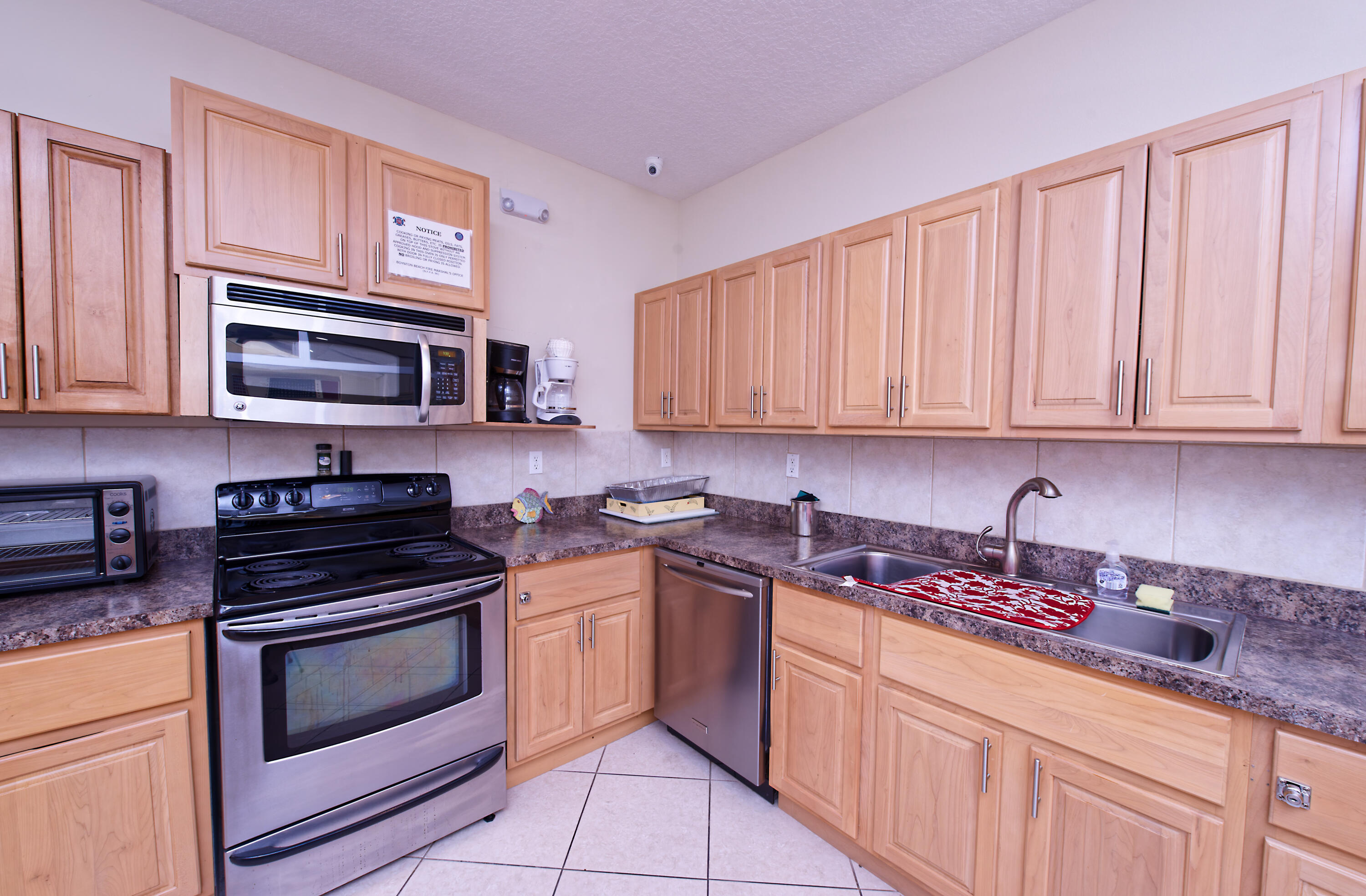 632 Snug Harbor Drive, Unit D15 Boynton Beach, FL 33435 - Photo 22 of 50 a kitchen with granite countertop a sink stove and microwave