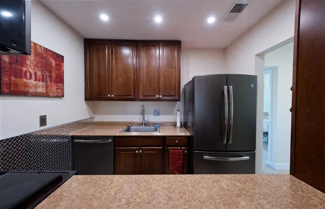 a kitchen with stainless steel appliances granite countertop a refrigerator and a sink