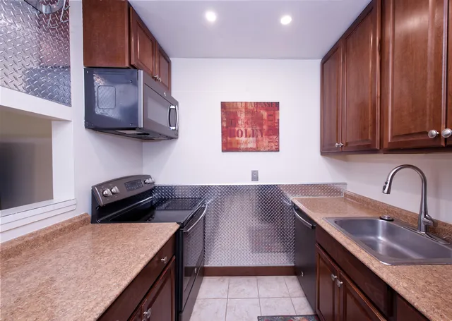 a kitchen with stainless steel appliances granite countertop a sink stove and cabinets