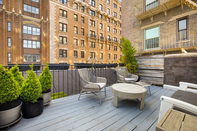 a view of a patio with couches chairs and wooden floor