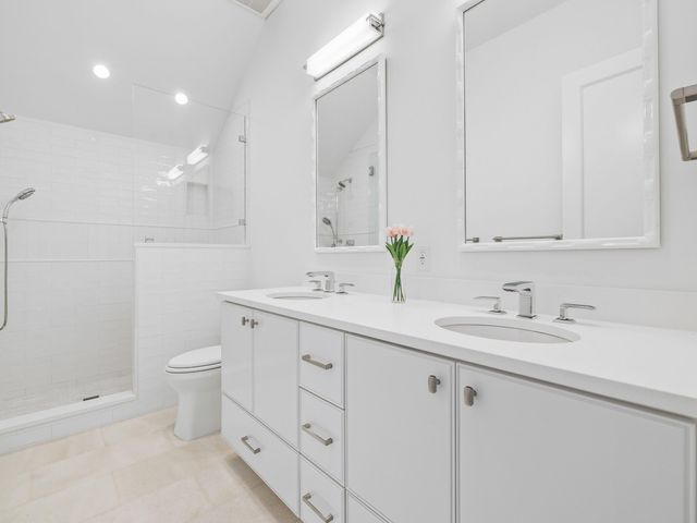 a bathroom with a granite countertop sink mirror and toilet