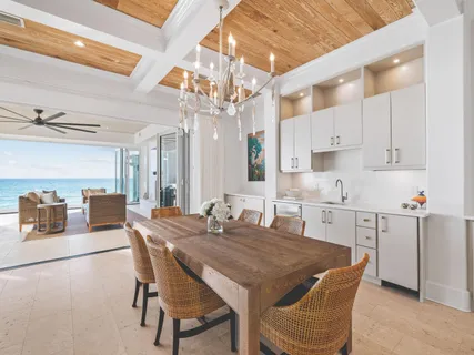 a kitchen with stainless steel appliances kitchen island granite countertop a dining table chairs and a refrigerator
