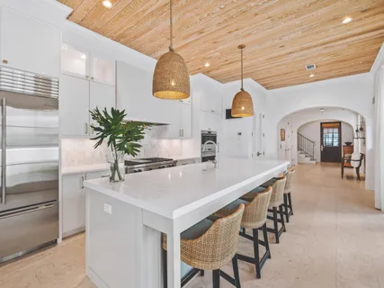 a dining room with wooden floor a chandelier a wooden table and chairs