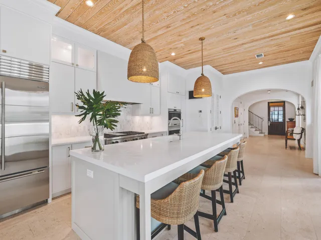 a dining room with wooden floor a chandelier a wooden table and chairs