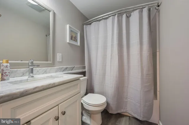a bathroom with a granite countertop toilet and a sink