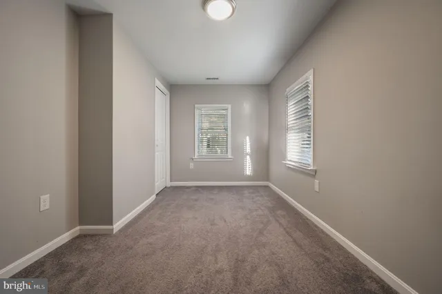 an empty room with windows and closet