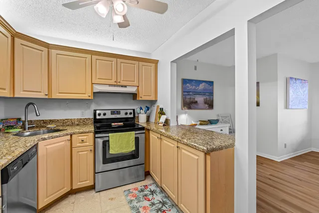 a kitchen with stainless steel appliances granite countertop a stove and cabinets