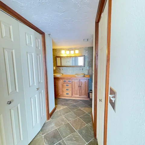 a view of a hallway with wooden floor and dining room
