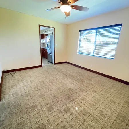 an empty room with windows and fan