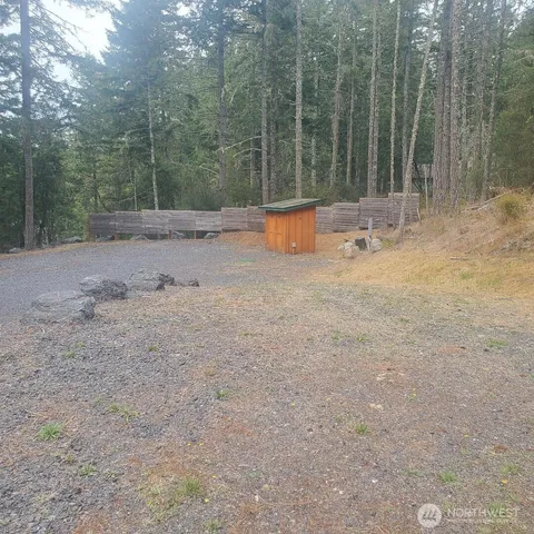 a backyard of a house with lots of green space and trees in the background