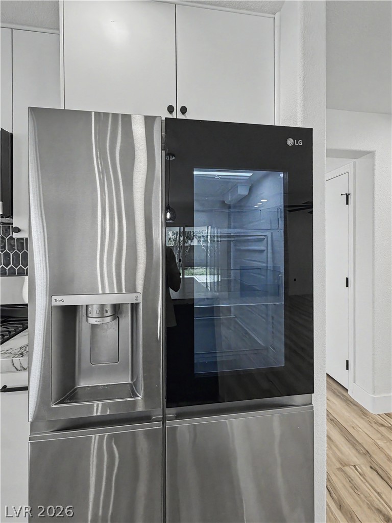 8977 Paige Rene Court Las Vegas, NV 89117 - Photo 11 of 31 A sleek stainless steel refrigerator with a clear view door anchors this modern kitchen.