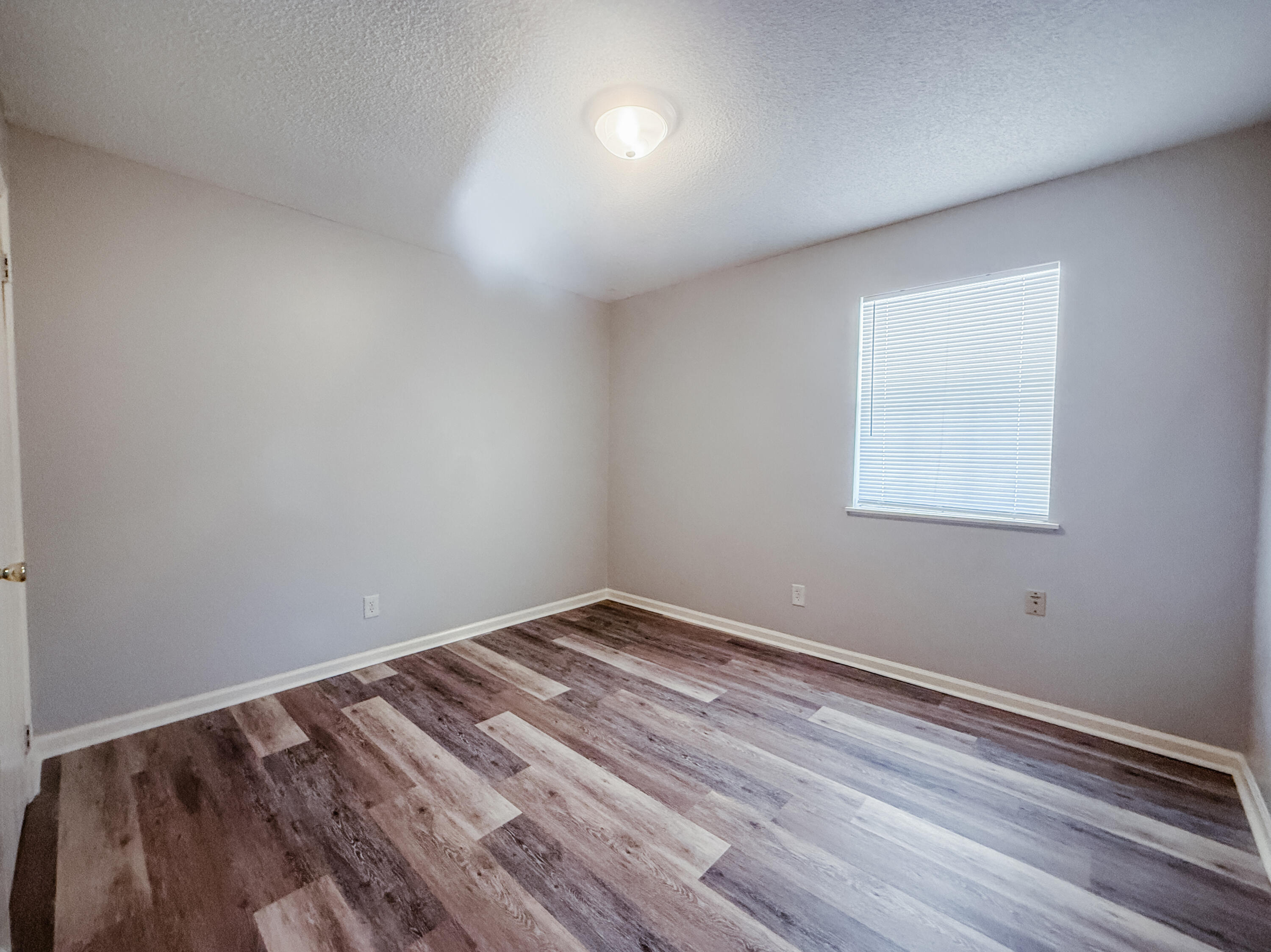 4260 Highway 90, Unit 42 Pace, FL 32571 - Photo 7 of 10 a view of room with wooden floor and fan