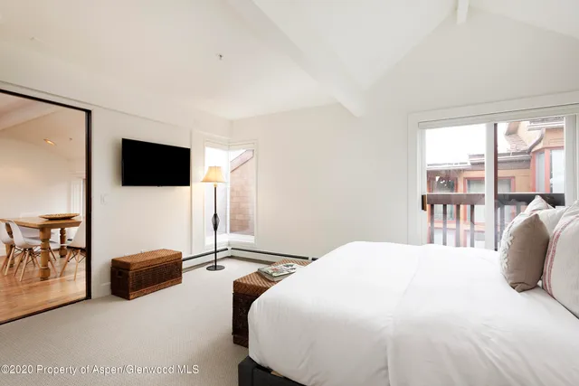 a bedroom with a bed and large window