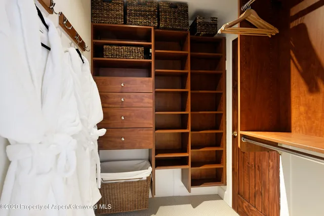 a view of walk in closet with empty racks