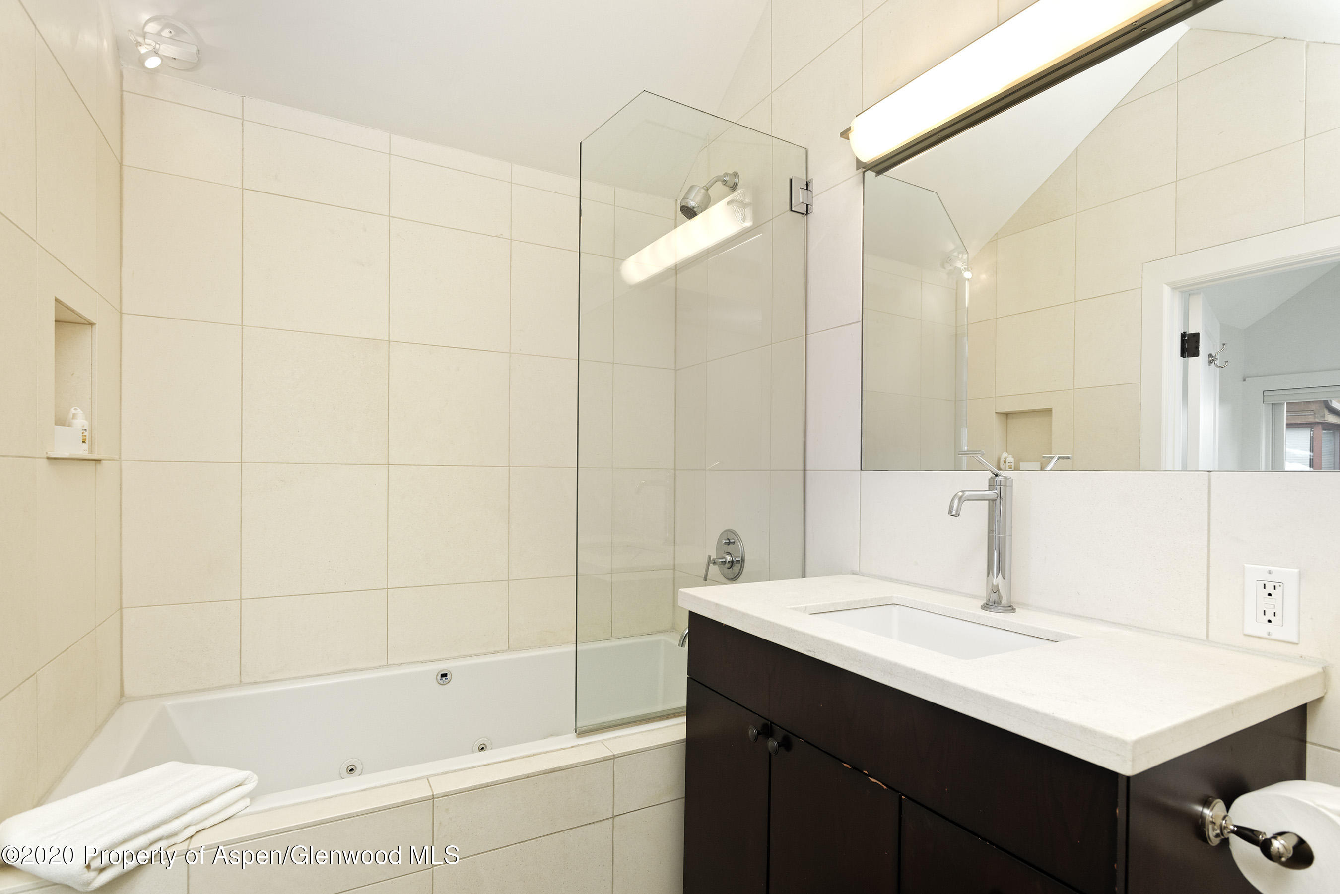 900 East Durant Avenue, Unit E114 Aspen, CO 81611 - Photo 9 of 13 a bathroom with a bathtub shower sink vanity and a mirror
