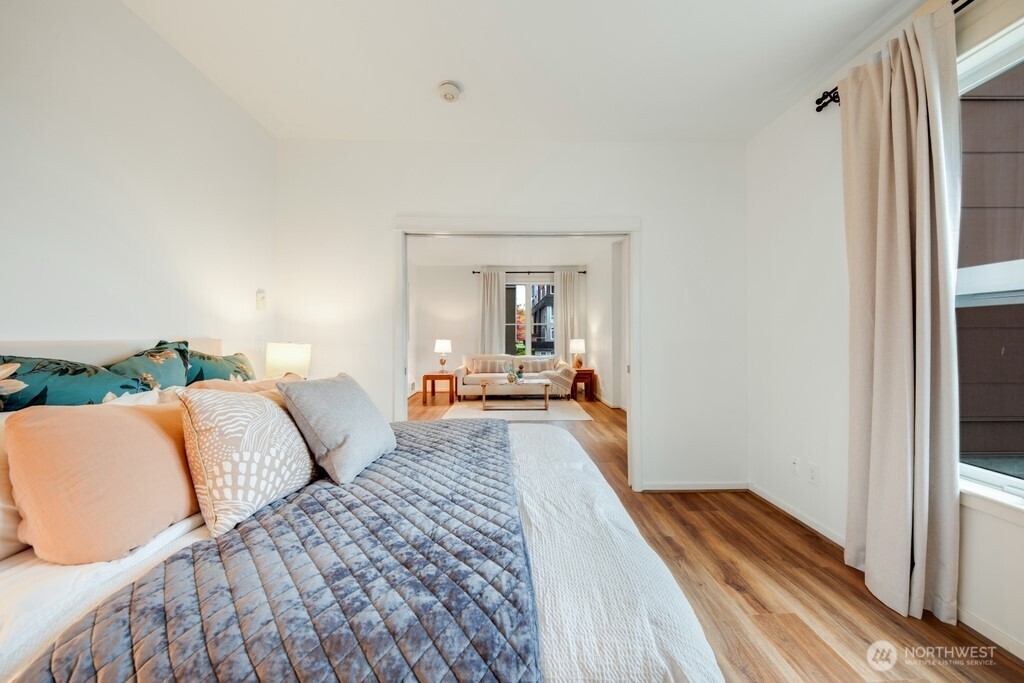 10042 Main Street, Unit 203 Bellevue, WA 98004 - Photo 10 of 30 a bedroom with furniture and a mirror