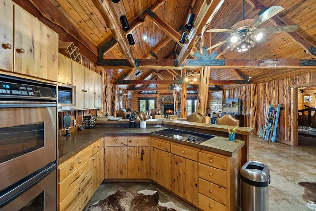 a large kitchen with stainless steel appliances granite countertop a sink and cabinets