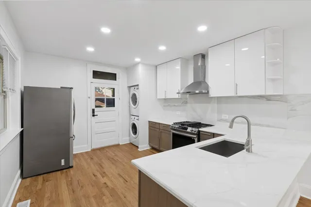 a kitchen with a refrigerator a sink and wooden cabinets