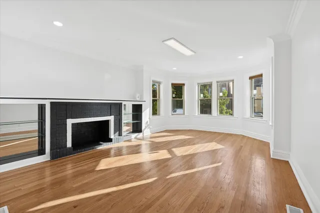 an empty room with wooden floor and fireplace