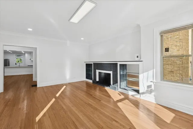 a view of a livingroom with wooden floor and kitchen