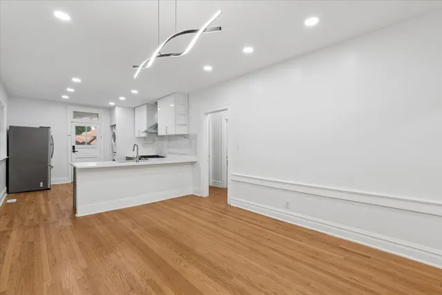 a large kitchen with a center island stainless steel appliances and cabinets