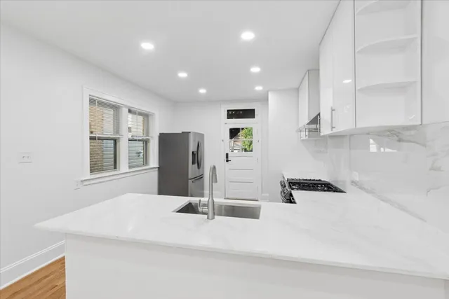 a kitchen with stainless steel appliances kitchen island sink refrigerator and microwave