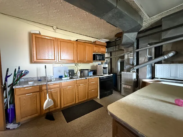 a kitchen with granite countertop a sink and cabinets