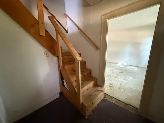 a bed sitting in a bedroom next to a window and dresser