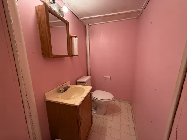 a bedroom with a bed lamp and mirror on the dresser