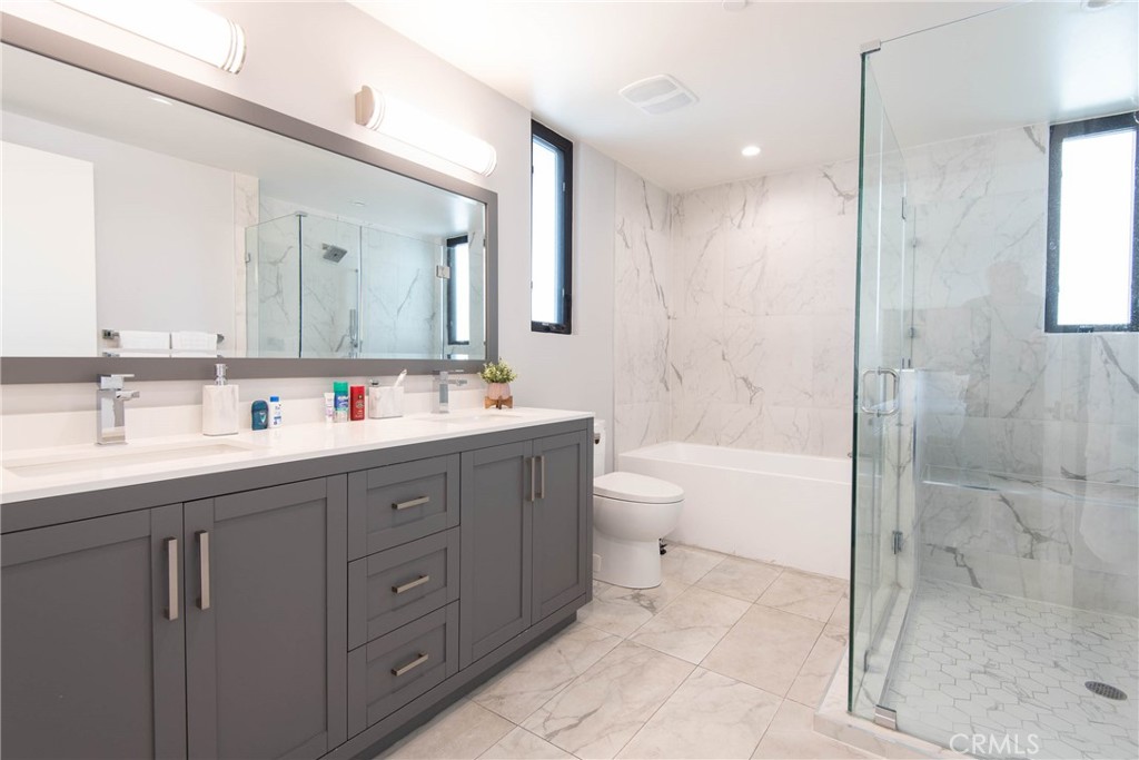 325 Myrtle Street, Unit 301 Glendale, CA 91203 - Photo 24 of 28 a bathroom with a double vanity sink mirror double shower and a bathtub