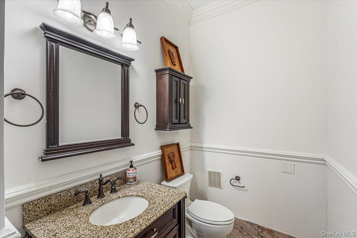 952 Cedar Swamp Road Glen Head, NY 11545 - Photo 35 of 50 a bathroom with a granite countertop sink toilet mirror and vanity