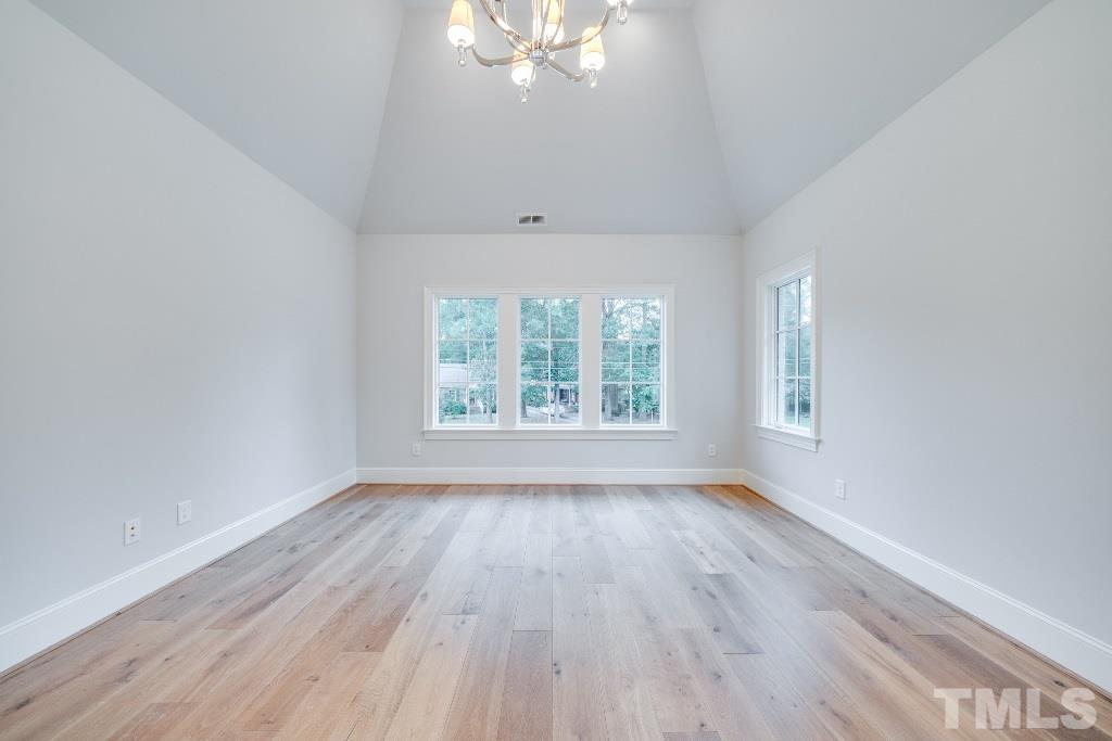 2015 Reaves Drive Raleigh, NC 27608 - Photo 22 of 30 an empty room with wooden floor and windows