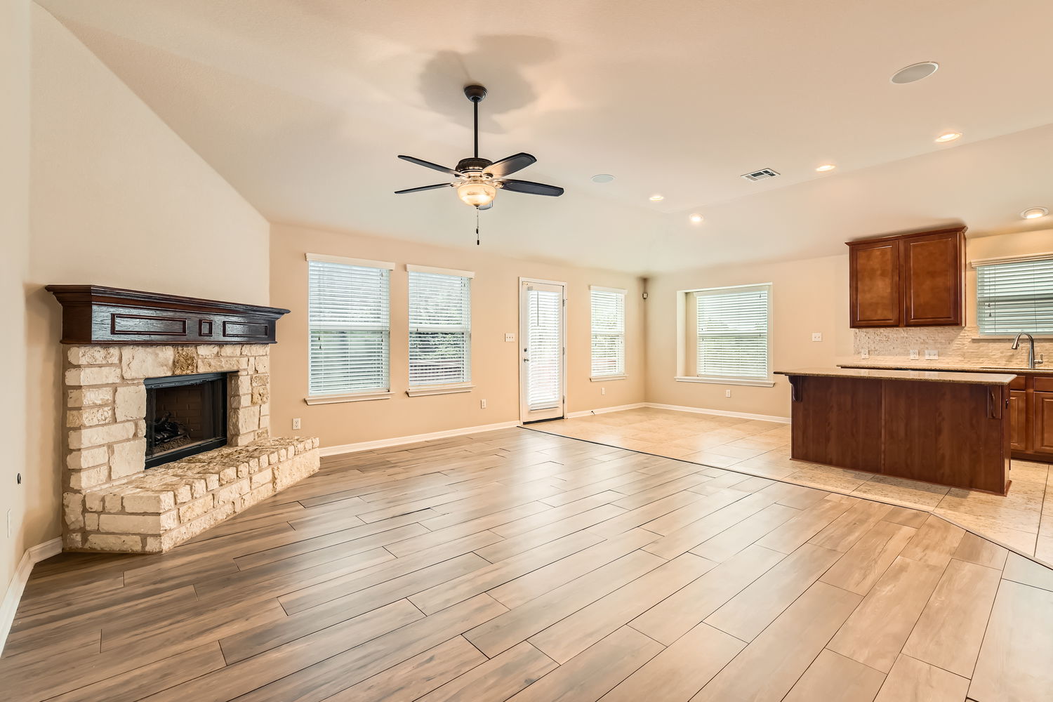 547 Stone View Trail, Unit 112 Austin, TX 78737 - Photo 5 of 28 a view of an empty room with a kitchen and a fireplace