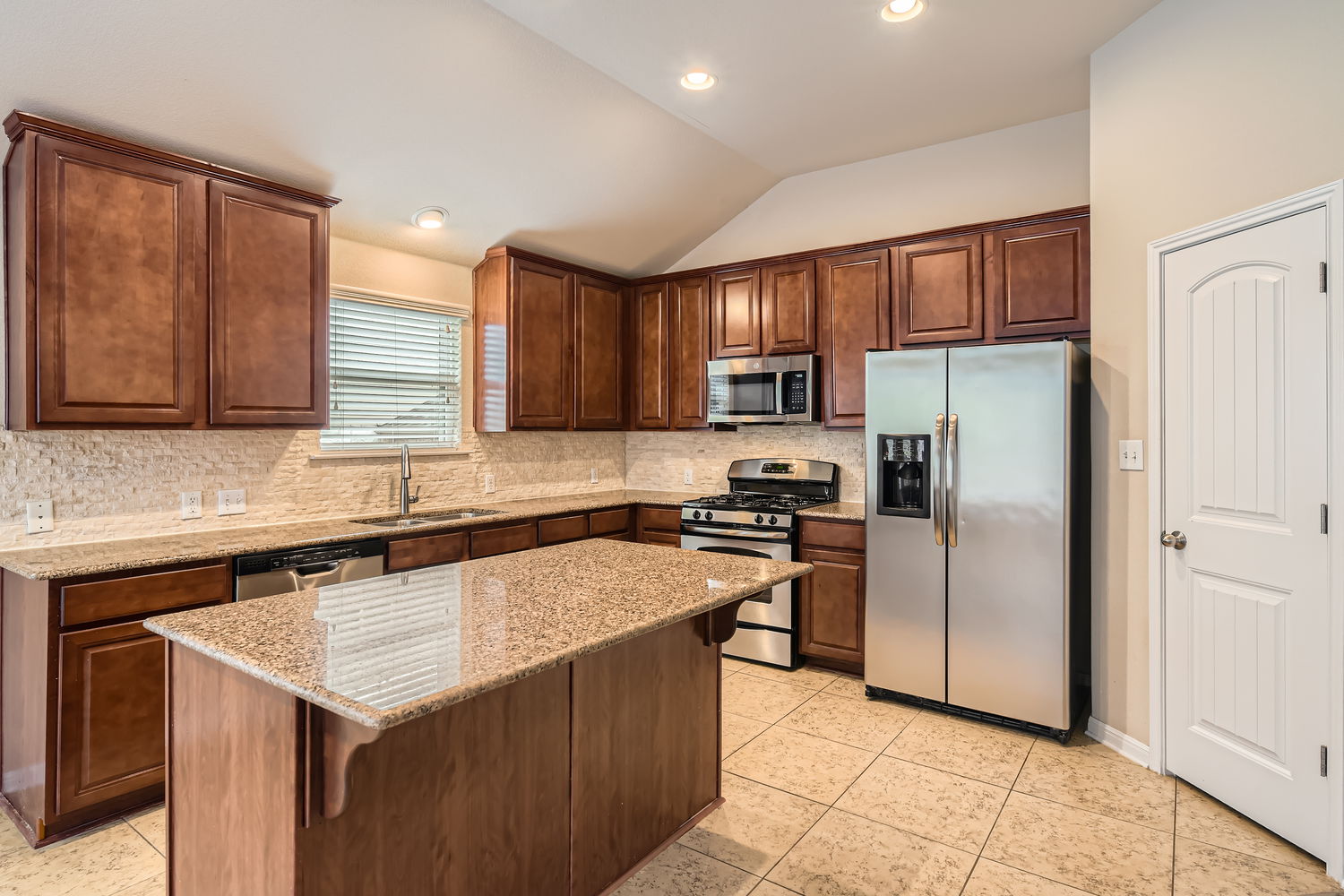 547 Stone View Trail, Unit 112 Austin, TX 78737 - Photo 8 of 28 a kitchen with stainless steel appliances granite countertop a refrigerator stove microwave and sink
