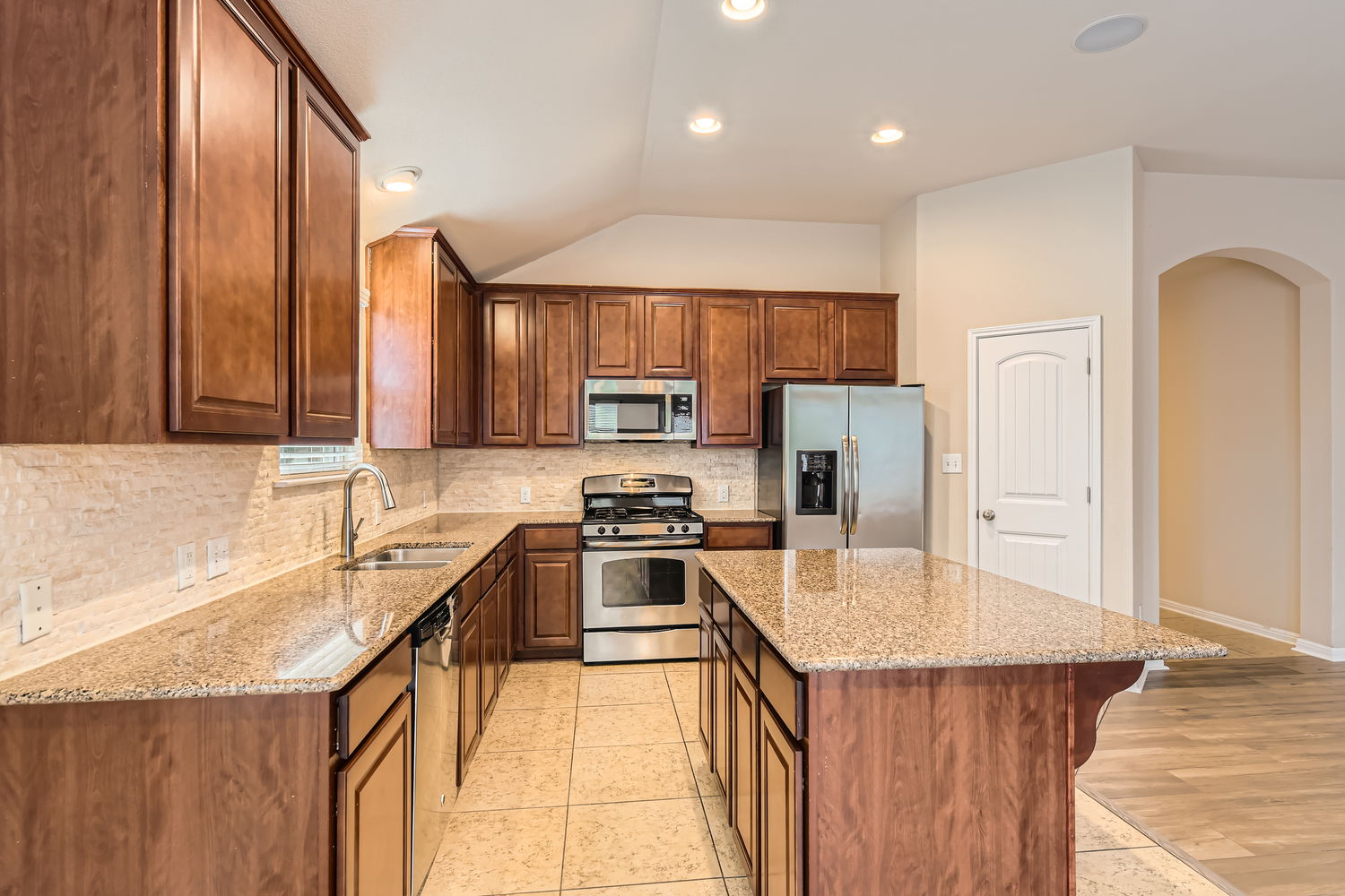547 Stone View Trail, Unit 112 Austin, TX 78737 - Photo 9 of 28 a kitchen with stainless steel appliances granite countertop a sink stove and refrigerator