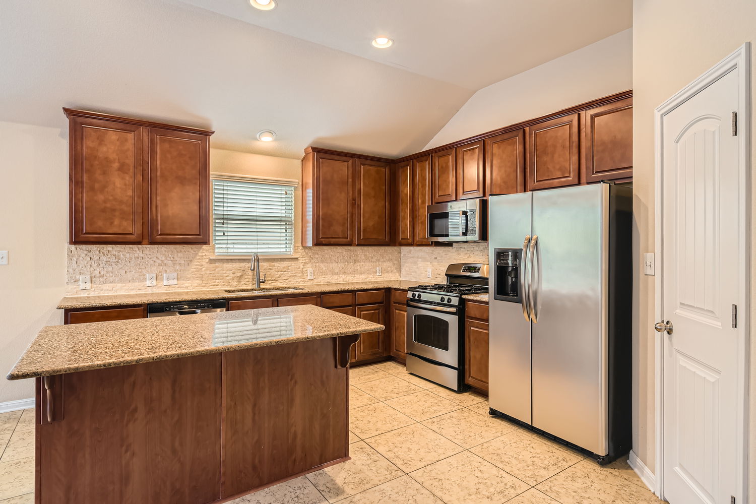 547 Stone View Trail, Unit 112 Austin, TX 78737 - Photo 10 of 28 a kitchen with stainless steel appliances granite countertop a refrigerator sink and stove