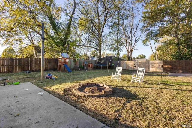 a view of a table and chairs in a backyard
